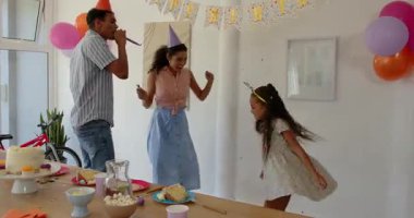 Doğum günü partisinde evde çeşitli aile dansları, abur cubur ve balonlarla doğum günü pastasının tadını çıkarmak. Kutlama, neşe, şenlik, toplanma, coşku, eğlence, çocuklar