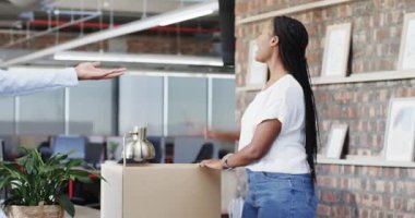 Afrika kökenli Amerikalı meslektaşlar modern ofiste kutlama yapıyor, vazolarla neşe dolu gülümsemeleri paylaşıyorlar. Kutlama, takım çalışması, işbirliği, modern, çalışma alanı, neşe, profesyonel