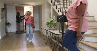 Çeşitli arkadaşlar modern ev koridorlarında yürürken gülüp sohbet ediyorlar. Arkadaşlık, sohbet, yaşam tarzı, birliktelik, gelişigüzel, bağlanma