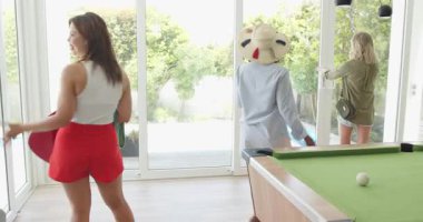 Çeşitli arkadaşlar tatil için eve geliyor, güneşli havuz bölgesini bitkilerle karşılıyorlar. Tatil, arkadaşlık, açık hava, rahatlama, yaz, toplanma, kutlama, doğa