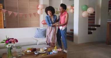 Evde doğum gününü kutlarken, çeşitli kadın çiftler birlikte pasta ve meyvenin tadını çıkarıyorlar. Kutlama, arkadaşlık, tatlı, neşe, parti, şenlik