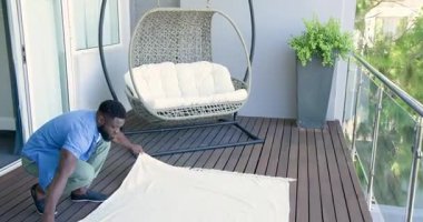 Afro-Amerikalı adam güvertede kapıyı itiyor hindistan cevizi üzümleri yerleştiriyor, servis panosu, kopyalama alanı. Açık hava, boş zaman, yaşam tarzı, kırsal, huzur, rahatlama, sosyal