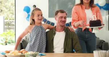 Çeşitli aileler yemek masasında 30 mum taşıyan çikolatalı pasta taşıyor ve doğum gününde babalarına sarılıyorlar. Kutlama, birliktelik, şefkat, mutluluk, evcil, kilometre taşı, neşe