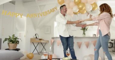 Sarıldıktan sonra, kıdemli çift mutfak adasında bayrak altında dans ediyor. Romantizm, kutlama, yakınlık, sevgi, zarafet, neşe, yaşam tarzı