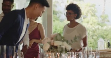 Asyalı bir adam yemek odasına giriyor çeşitli arkadaşlarıyla yemek masasında oturup sohbet ediyor. Kutlama, yoldaşlık, sofistike, etkileşim, zarafet, neşe, sosyalleşme