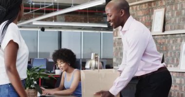 Çeşitli iş arkadaşları modern ofiste ödül törenini çerçeveli sanat eserleri ve ödüllerle kutluyorlar. Kutlama, meslektaşlar, başarı, tanınma, modern, profesyonel, takım çalışması