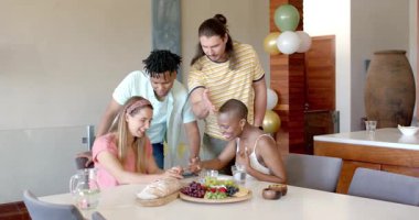 Partide, arkadaşlar evde çerez ve sohbetin tadını çıkarıyorlar, gülümsüyorlar ve birlikte rahatlıyorlar. Boş zaman, toplanma, gündelik, mutluluk, sosyalleşme, kaynaşma