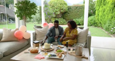 Evde kutlama, şampanyayla kadeh kaldıran ve pastanın tadını çıkaran olgun bir çift. Kutlama, yıldönümü, tatlı, romantizm, mutluluk