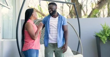 Afro-Amerikalı erkek sürpriz partner, gözleri kapatıyor ve balkona doğru hediyeyle salıncakta sallanıyor. Romantizm, mahremiyet, kutlama, açık hava, eğlence, yaşam tarzı, neşe