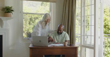 Üst düzey beyaz kadın, ofisteki dizüstü bilgisayarında evrak hazırlayan Afro-Amerikalı adama tezahürat ederek kazanıyor. Akıl hocalığı, işbirliği, başarı, kutlama, takım çalışması, pozitif iletişim