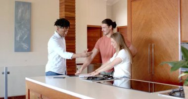 Partide, modern mutfakta, arkadaşlar planları tartışıyor ve birlikte gülümsüyorlar. Arkadaşlık, sohbet, birliktelik, gündelik, yaşam tarzı, etkileşim