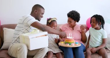 Afro-Amerikan ailesi doğum gününü evde kutluyor, ellerinde hediyeler ve pastalar var. Kutlama, pasta, aile, konfor, eğlence, şenlik, birliktelik, hediyeler, dekorasyon