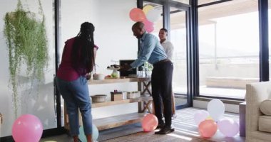 Modern ofiste yürüyen meslektaşlar renkli balonlar ve şenlikli dekorasyonlarla kutlama yapıyorlar. Kutlama, takım çalışması, canlı, iletişim, balonlar, şenlikli, modern