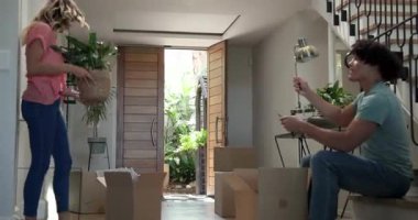 Yeni evdeki kutuları açan, eşyaları düzenleyen ve düzenleyen genç bir çift. Taşınma, taşınma, yaşam tarzı