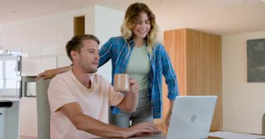 Evde dizüstü bilgisayar kullanırken iş tartışan çift, proje üzerinde işbirliği yapıyor. İşbirliği, takım çalışması, uzaktan çalışma, iş, ortaklık, beyin fırtınası