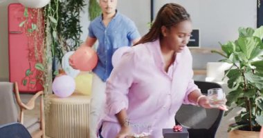 Genç yetişkin erkek ofis doğum gününü çikolatalı pasta, meyve ve balonlarla düzenliyor. Kutlama, ofis, şenlik, eğlence, pasta, meyve, toplama