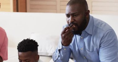 Aile kanepede abur cuburları birlikte yiyor, kahkahaları ve sohbetleri paylaşıyor, Homd 'da. Aile zamanı, bağlanma, birliktelik, rahatlama, mutluluk, oturma odası.