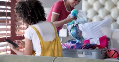 Çeşitli kadın çiftler evde bavullarını topluyor, gülümsüyor ve seyahat hazırlıklarının keyfini çıkarıyorlar. tatil, yaşam tarzı, macera, ilişki