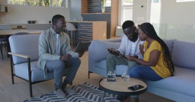 Siyah tabletle modern evde birbirlerini tebrik eden Afrikalı Amerikalı arkadaşlar. Dostluk, kutlama, çağdaş, sıcak, etkileşim, ev, pozitif, modern