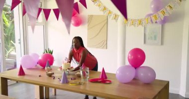 Doğum günü partisi odasına girerken, Afrika kökenli Amerikalı bir çift masada şapka balonları düzenliyor. Kutlama, şenlik, dekor, neşe, arkadaşlık, neşe, eğlence