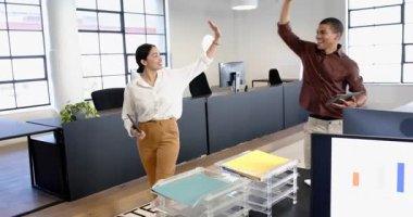 İş adamı ve iş kadını modern ofiste dizüstü bilgisayar kullanıyor ve tezahürat yapıyor. Teknoloji, iletişim, iş, iş ve ofis ortamı kavramı.