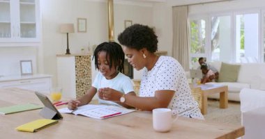 Afrika kökenli Amerikalı anne ve oğul modern evdeki masada deftere tablet çiziyorlar. Yaratıcılık, aile, eğitim, işbirliği, ilham, sıcak, modern