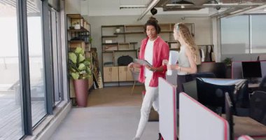 Çeşitli meslektaşlar ofis içinde cam pencereli ve tabletli takım arkadaşlarını tebrik ediyor. Kutlama, takım çalışması, ofis, işbirliği, modern, pozitiflik, başarı