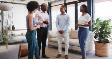 Çeşitli meslektaşlar modern ofis alanında takım ödülünü kanepe, bitki ve dokuma halıyla kutluyor. Tören, takım çalışması, başarı, kutlama, modern, ödüller, profesyonel