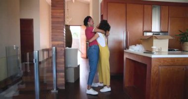 Modern mutfakta kucaklaşan çeşitli kadın çiftler yeni evlerinde kutularını açıyorlar. Taşınma, taşınma, yaşam tarzı, birliktelik, ilişki