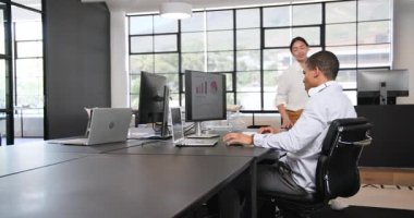 İş kadını ve iş adamı modern ofiste bilgisayar kullanıyor, tezahürat yapıyor ve beşlik çakıyor. İş, iş ve ofis ortamı kavramı.