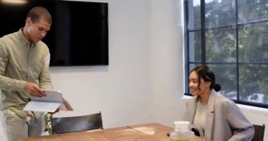 Mutlu meslektaşlar el sıkışıyor, kağıtları kontrol ediyor, ofiste dizüstü bilgisayar kullanıyor. Toplantı, iş, iş, ofis çalışma ortamı kavramı.