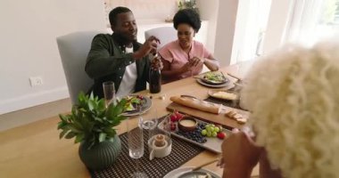 Çeşitli çiftler evde şarap ve salatadan keyif alıyor, birlikte kutluyorlar. Kutlama, romantizm, birliktelik, yemek, aşk, yaşam tarzı