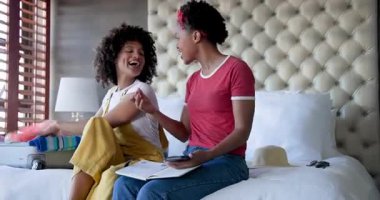 Çeşitli kadın çiftler yataklarına bavullarını topluyor, gülümsüyor ve birlikte tatile hazırlanıyorlar, evde. Seyahat, bagaj, turizm, tatil, ilişki, yolculuk