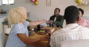 Çeşitli arkadaşlar yemek masasında sohbet etmekten ve kahkaha atmaktan hoşlanıyorlar. Sosyalleşme, gülme, kaynaşma, akşam yemeği, eğlence