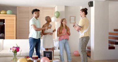 Evlerinde kutlama yapıyorlar, arkadaşları şampanyalarını kızartıyorlar ve etraflarında da şenlik süsleri var. Kutlama, parti, sosyalleşme, toplanma