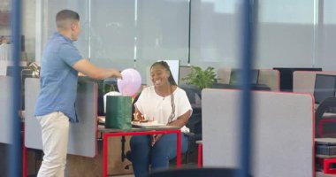 Muhtelif arkadaşlar ofis doğum gününü modern odalarda kutluyor, pasta ve balonun tadını çıkarıyorlar. Kutlama, doğum günü, takım çalışması, iş arkadaşları, mutluluk, ofis, balonlar