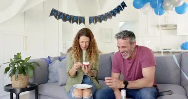 Son sınıf çifti kanepede bayrak altında doğum günü kutluyor, kekleri açıyor, şarap kızartıyorlar. Romantizm, kutlama, neşe, eğlence, evcimen, keyifli, sıcak