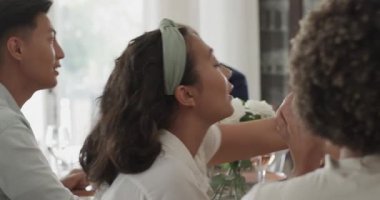 Farklı arkadaşlar, sakallı siyahi adamın hikâyesini dinliyorlar, şarap içip yemek masasında kadeh kaldırıyorlar. Kutlama, yoldaşlık, dostluk, sosyal toplantı, neşeli, sıcak, açık havada ilham verici.