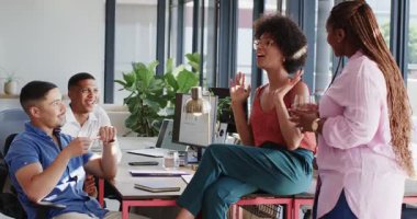 Modern ofiste çeşitli iş arkadaşları dizüstü bilgisayar ve not defterleri kullanarak sözleşme detaylarını tartışıyor. İşbirliği, müzakere, ekip, katılım, profesyonellik, çalışma alanı, iletişim