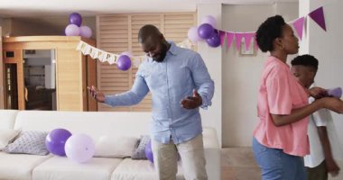 Babam Homd 'daki doğum günü kutlamaları için oturma odasında kek taşıyor. Ebeveynlik, parti, tatlı, ev hayatı, neşe, aile