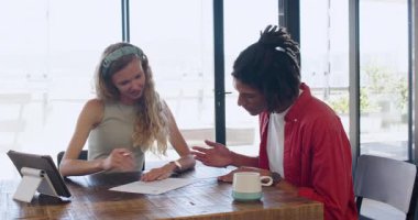 Çeşitli iş arkadaşları modern çalışma alanlarında yürüyor, tablet, belgeler ve kupalarla kutlama yapıyorlar. İşbirliği, verimlilik, takım çalışması, başarı, gündelik, modern, beyin fırtınası