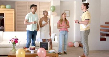 Arkadaşlar yeni işi pasta ve şampanyayla kutluyor, neşeyle gülümsüyor. Kutlama, parti, tebrikler, mutluluk, toplanma, eğlence