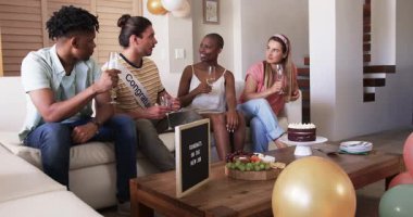 Arkadaşlar evde içkinin ve abur cuburun tadını çıkarıyor, birlikte gülüşerek kutluyorlar. Parti, toplanma, arkadaşlık, kutlama, yemek, eğlence