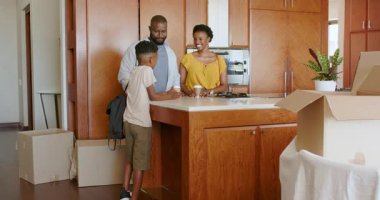 Mutlu aile yeni mutfağa yerleşiyor, gülümsüyor ve yeni evlerinin tadını çıkarıyorlar. taşınma, taşınma, mutluluk, ev hayatı, yaşam tarzı