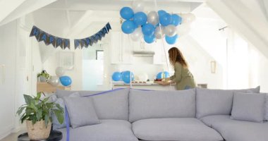 Mutfakta parti balonları ayarlamak, kadın kek düzenlemek, abur cubur tahtası yapmak, şişe taşımak. Şenlik, kutlama, dekor, konukseverlik, neşeli, modern, aşçılık