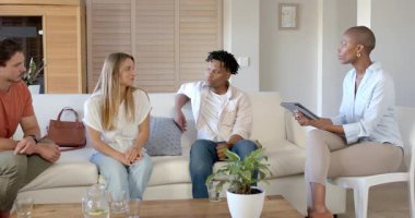 Çeşitli arkadaşlar kanepede dinleniyor, evde sohbetin ve kahkahanın tadını çıkarıyorlar. Arkadaşlık, kaynaşma, boş zaman, günlük, toplanma, iletişim