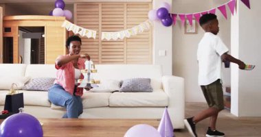 Evde kutlama yapan Afro-Amerikan çift, kutlama partisinde keklerin tadını çıkarıyor. Kutlama, şenlik, neşe, tatlı, mutluluk, birliktelik