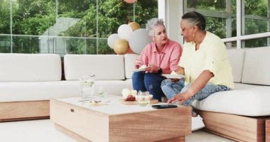 Üst düzey arkadaşlar rahat iç mekanda iyileşmeyi kutluyorlar, ahşap masada akıllı telefonla yemek paylaşıyorlar. Kutlama, dostluk, iyileşme, modern, toplanma, rahatlık, neşe, sohbet