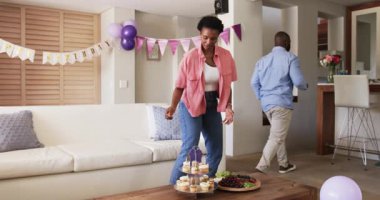 Oturma odasında parti düzenlemek, Afro-Amerikan çiftin evde kek süslemesi. Kutlama, dekorasyon, birliktelik, şenlikler, tatlılar, dostluk