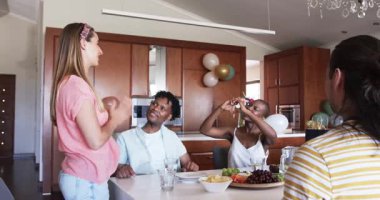 Partide, arkadaşlarla kutlama, kadeh kaldırma, atıştırmalıkları paylaşma ve evde gülme. Kutlama, dostluk, birliktelik, parti, tezahürat, toplantı